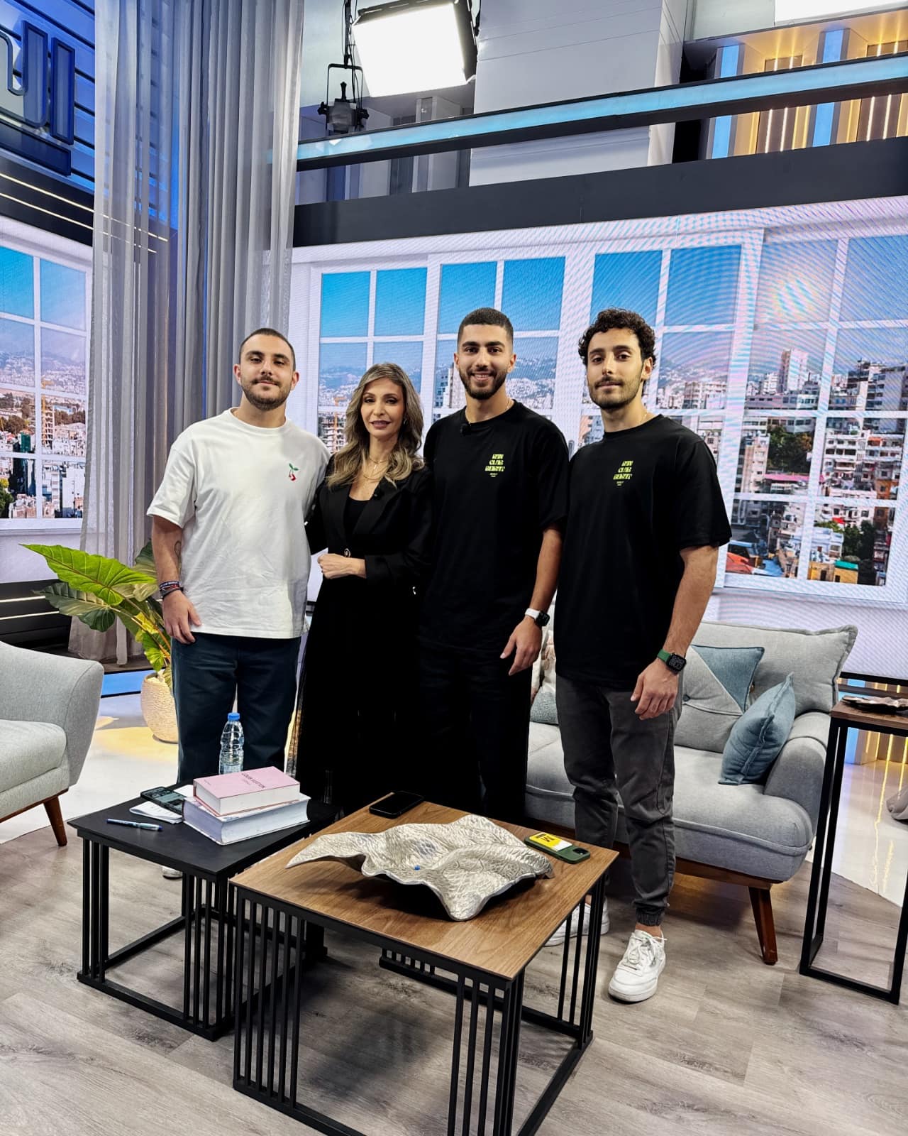 The three Run Club Beirut co-founders standing together in a television studio with a presenter, two of them in club shirts