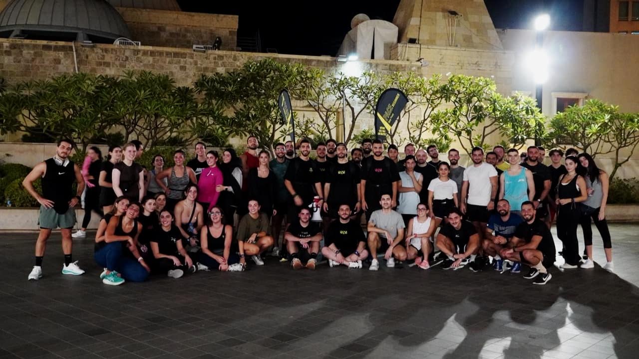 The whole Run Club Beirut community together for a group photograph in the city at night