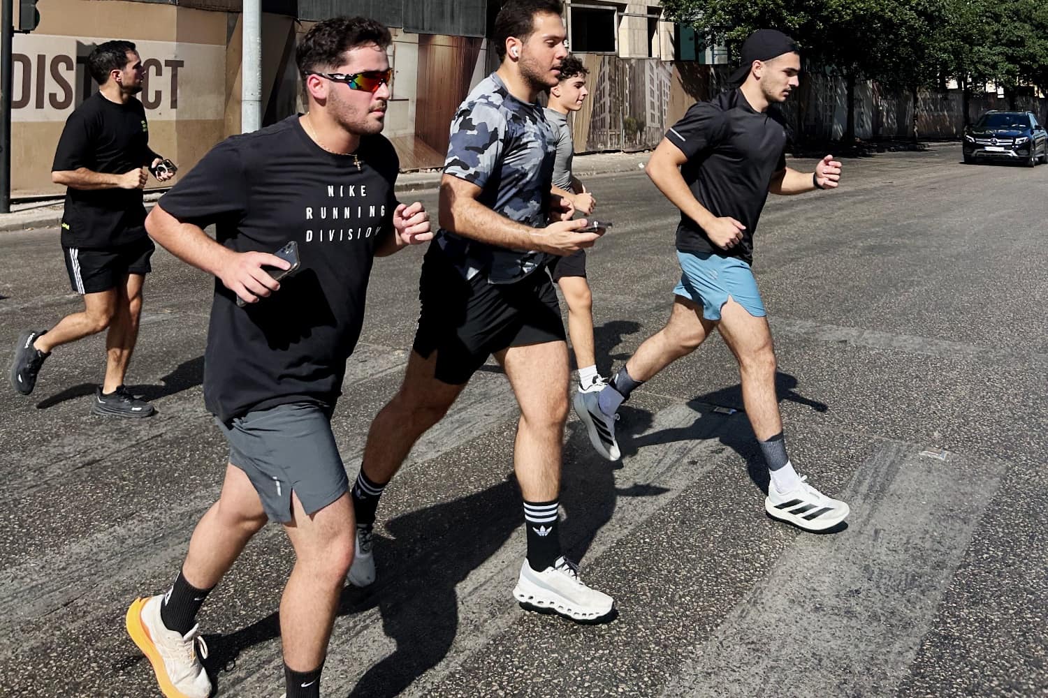 Four Run Club Beirut runners mid-stride down a sunlit Beirut street