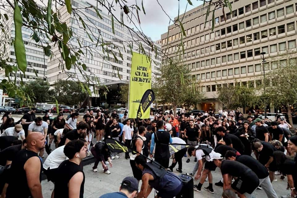 The Run Club Beirut community gathered at dusk in a downtown Beirut plaza, the club banner flying